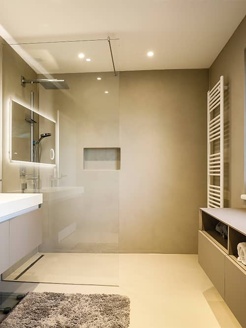 Fugenloses Bad in Beige, bodengleiche Dusche mit Wandnische und durchgehendem Boden