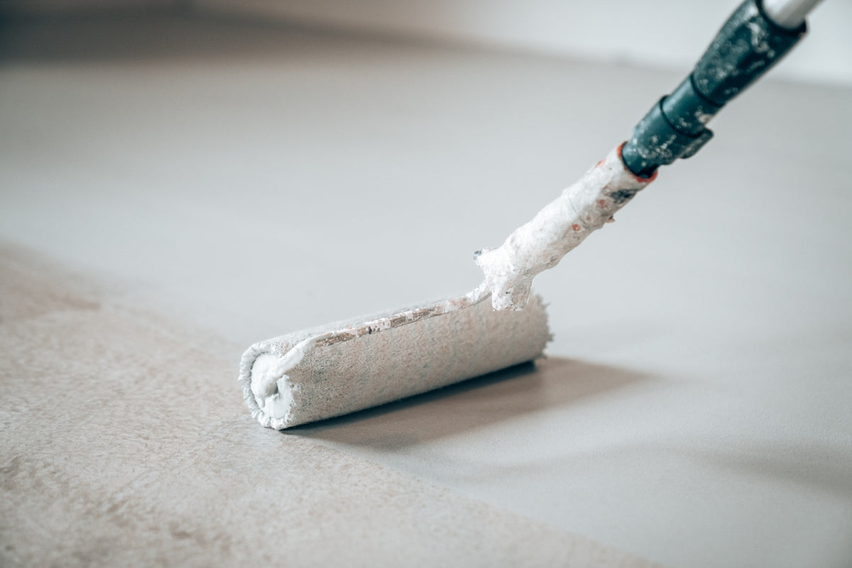 Primer being applied to the floor with a roller