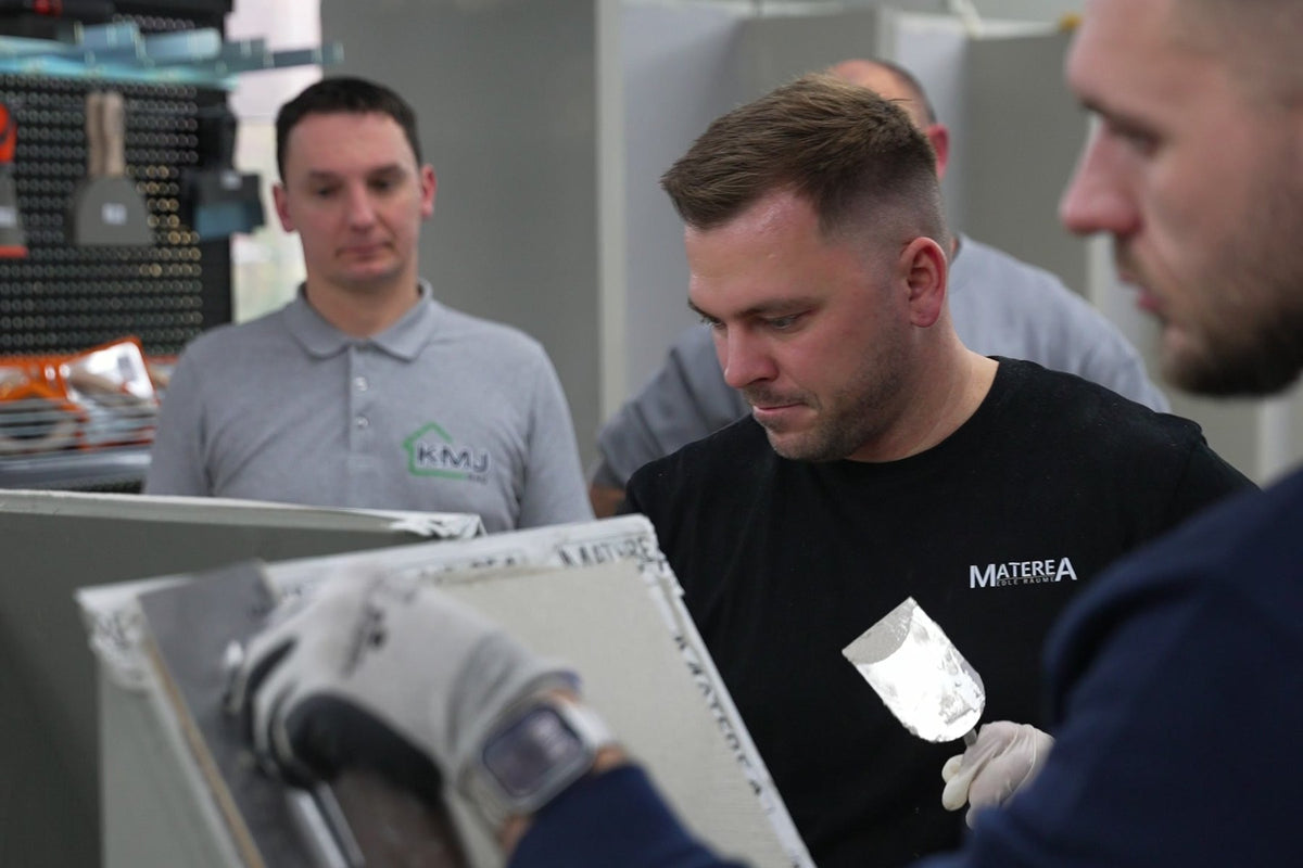Im Materea-Workshop wird eine Musterplatte gespachtelt, die Teilnehmer schauen zu